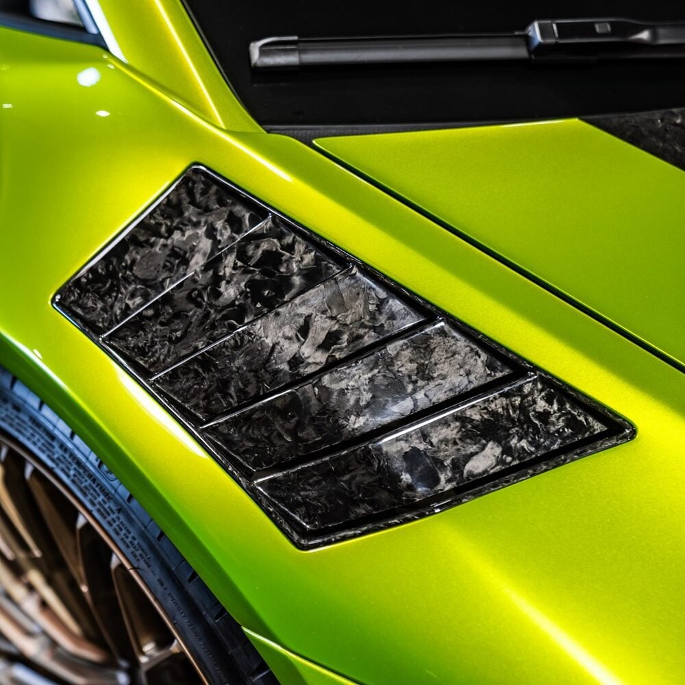 Close-up of forged carbon fender vent louvers on a lime green Huracan