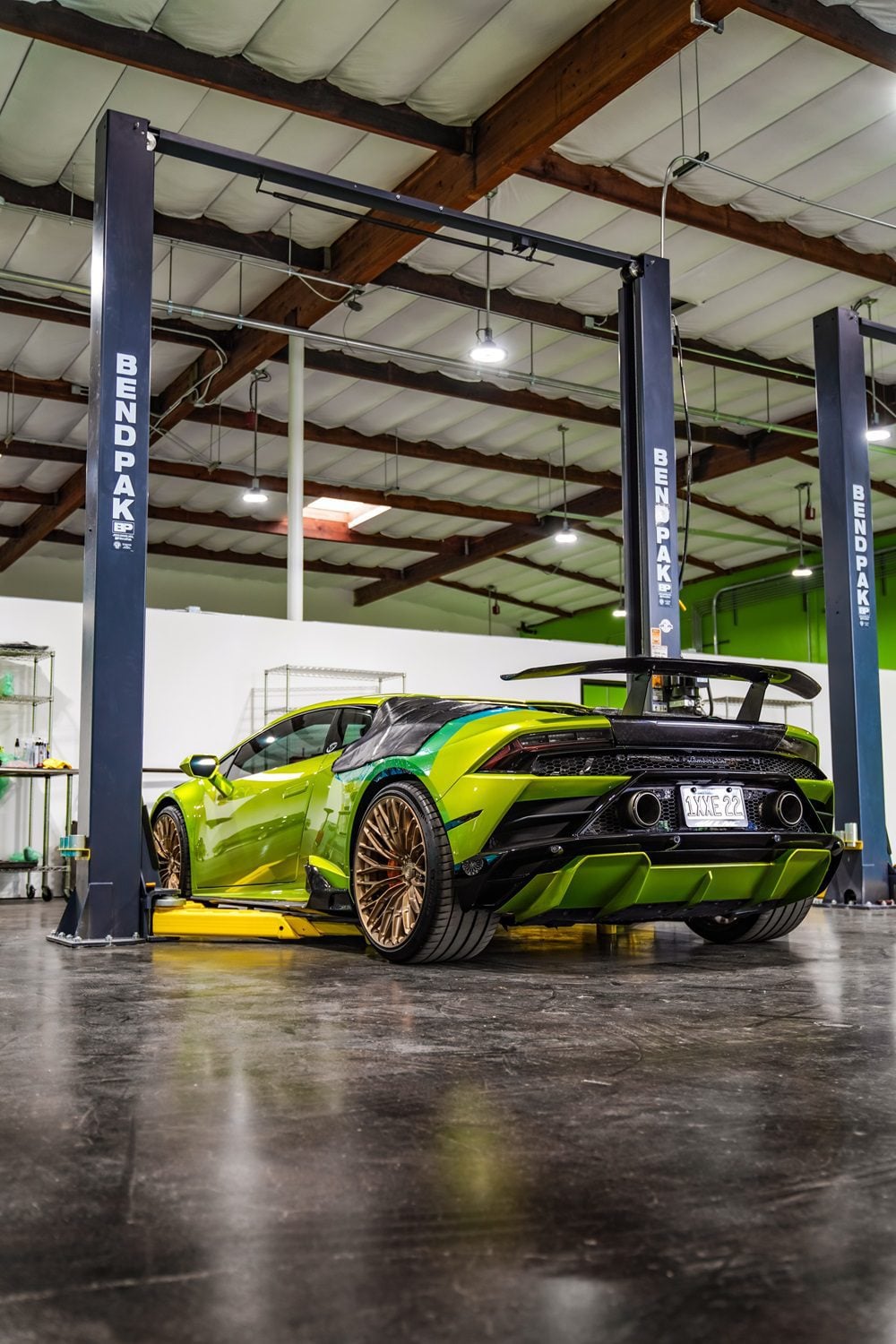 Lime green Lamborghini Huracan Evo rear three-quarter showing the carbon rear diffuser in a garage