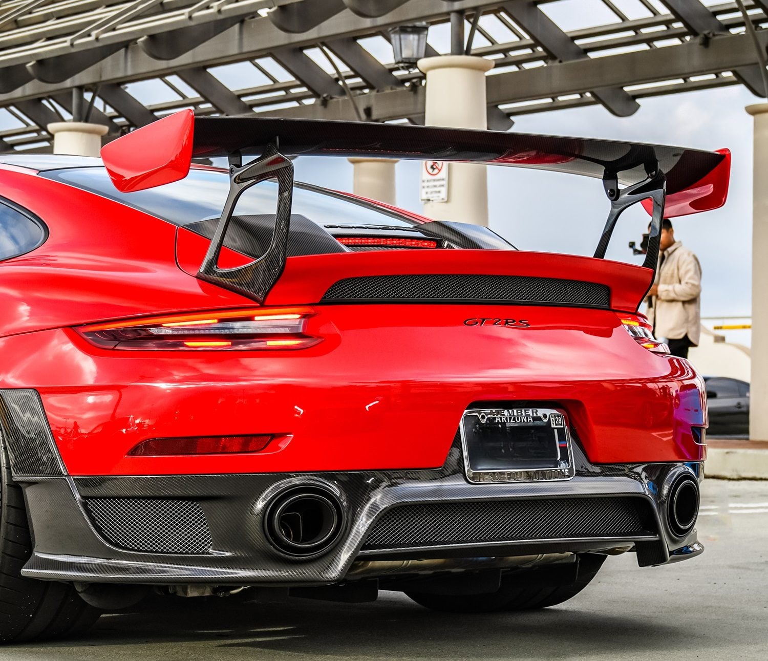 Red Porsche 911 GT2 RS rear view with carbon wing legs
