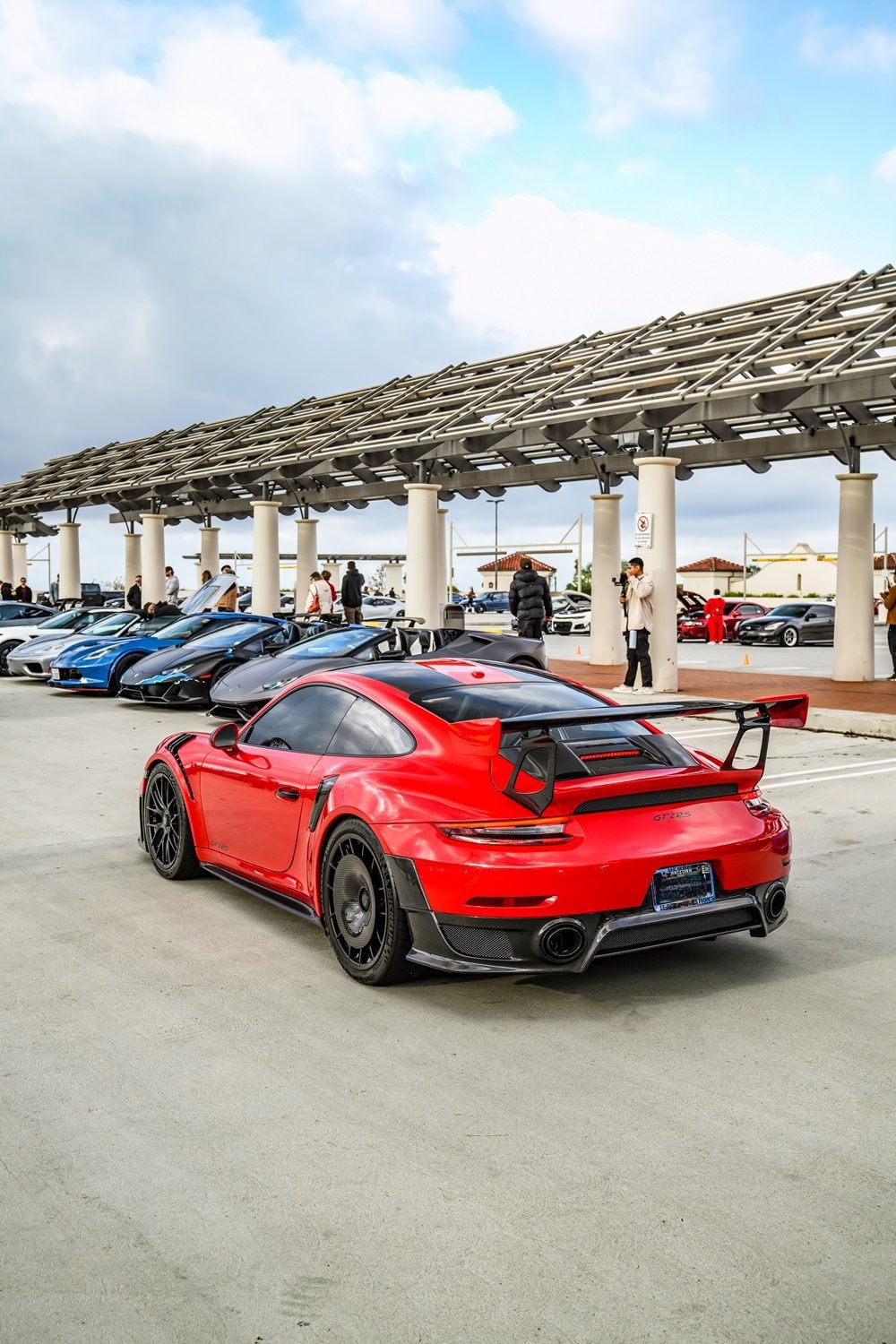 Red Porsche 911 GT2 RS rear three-quarter at a car meet showing the rear diffuser