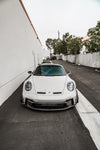 White Porsche 911 GT3 (992) front view with the 1016 vented hood in an alley