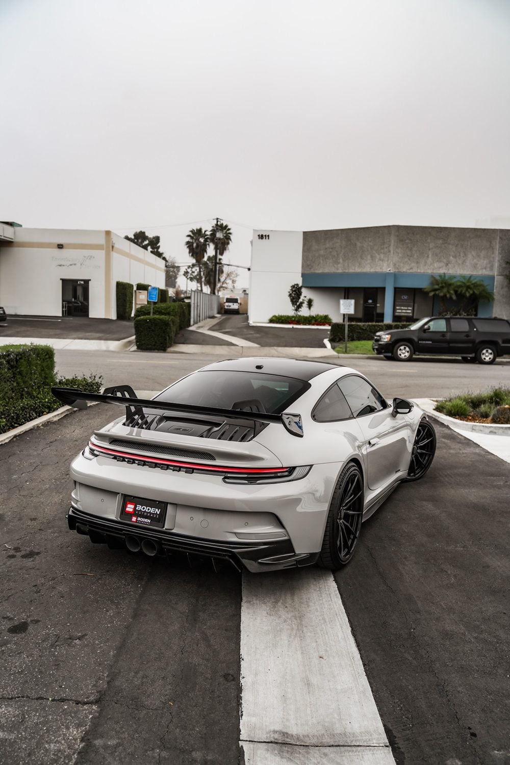 Grey Porsche 911 GT3 (992) rear three-quarter with carbon wing blade