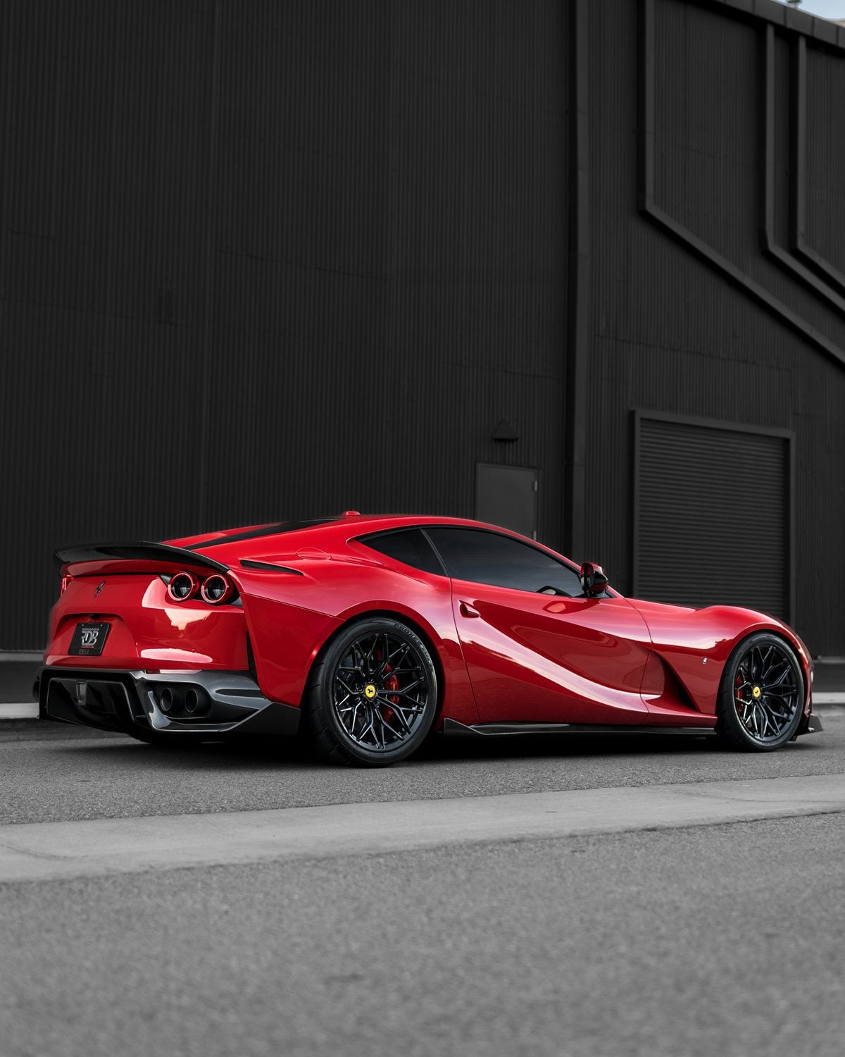 Red Ferrari 812 rear three-quarter showing the carbon rear diffuser