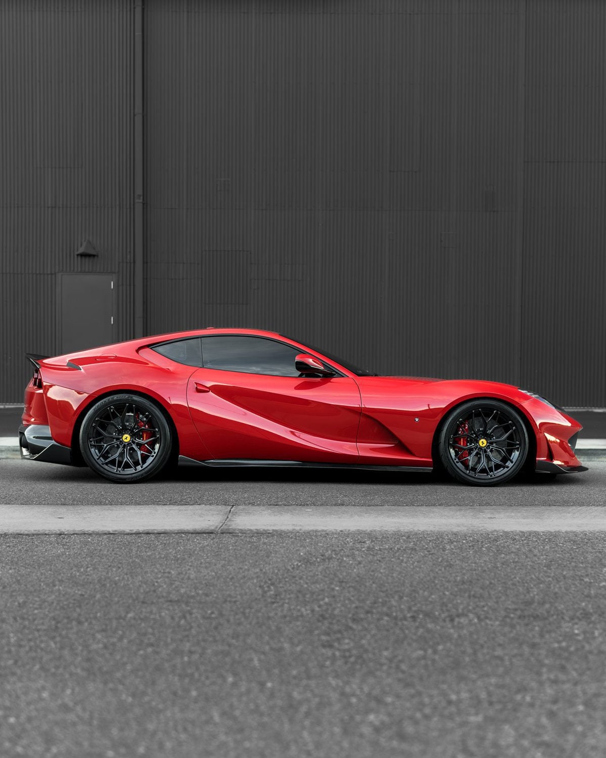 Red Ferrari 812 side profile showing carbon side skirts