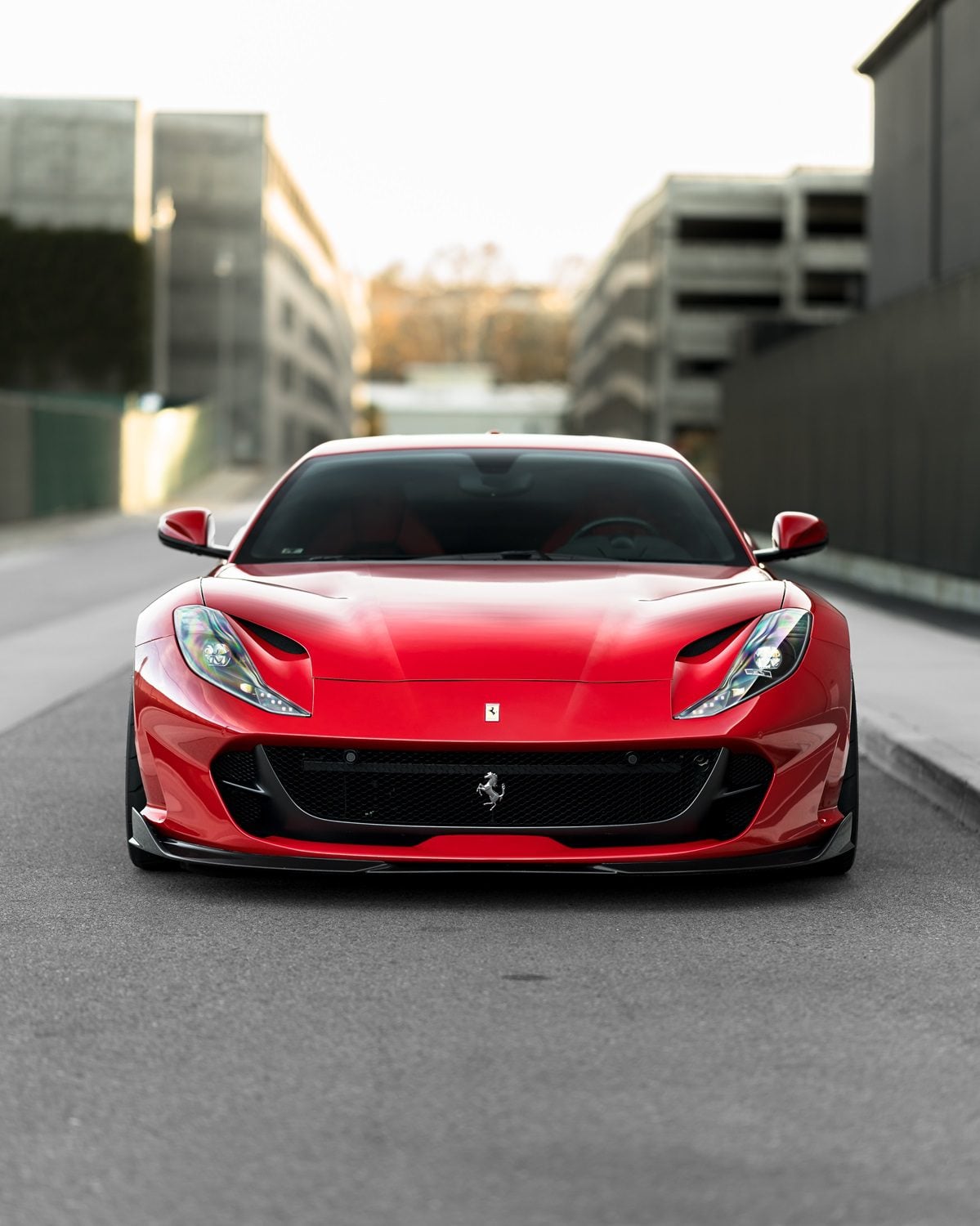 Red Ferrari 812 head-on on a city street with front aero lip
