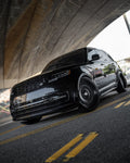 Black Range Rover Vogue with the 1016 full body kit under a bridge, low front angle