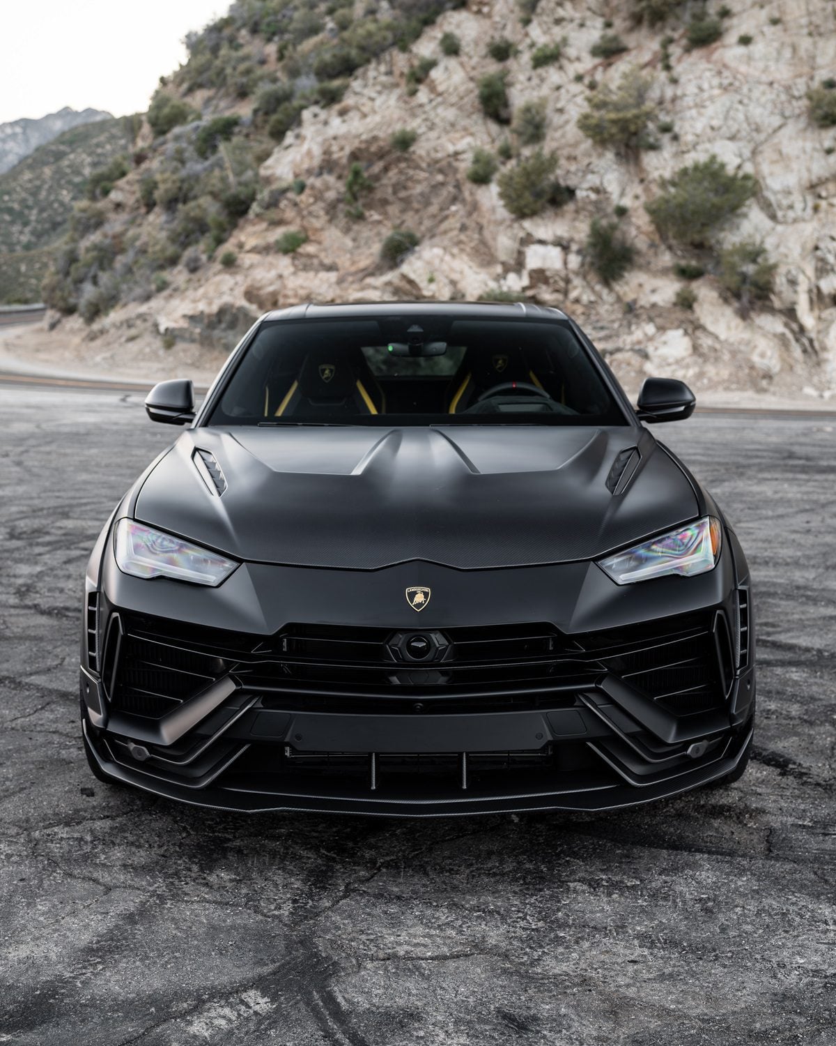 Black Lamborghini Urus head-on on a mountain road