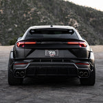 Black Lamborghini Urus straight rear view on a mountain road