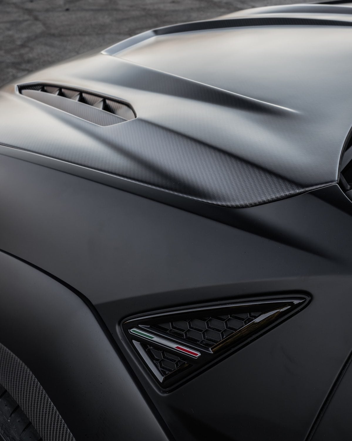 Carbon hood and fender vents on a matte black Lamborghini Urus Performante, close-up