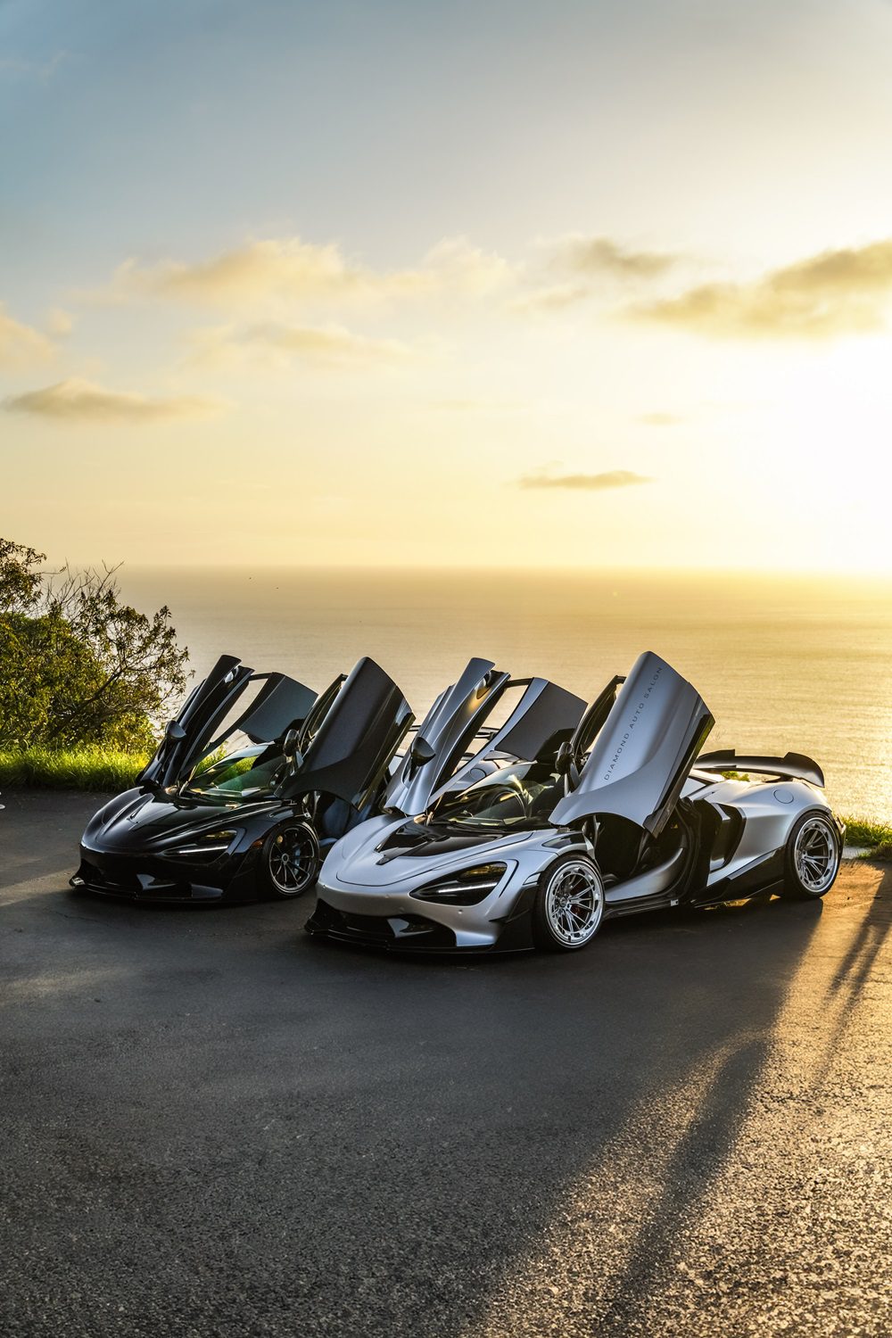 Black and silver McLaren 720S pair with the Vision package at sunset, doors up