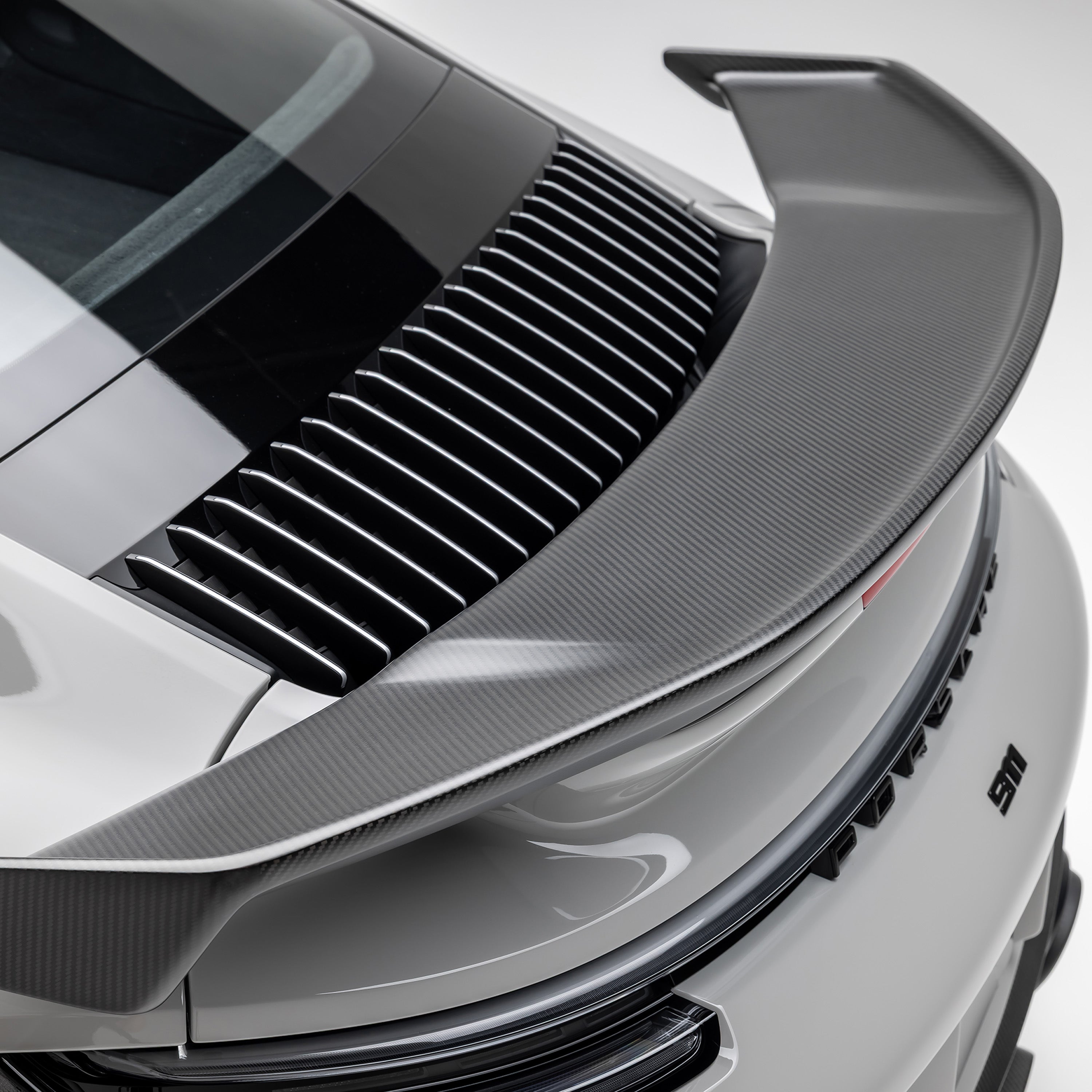 Vorsteiner rear wing over engine grille on 992 Turbo S, top-down detail