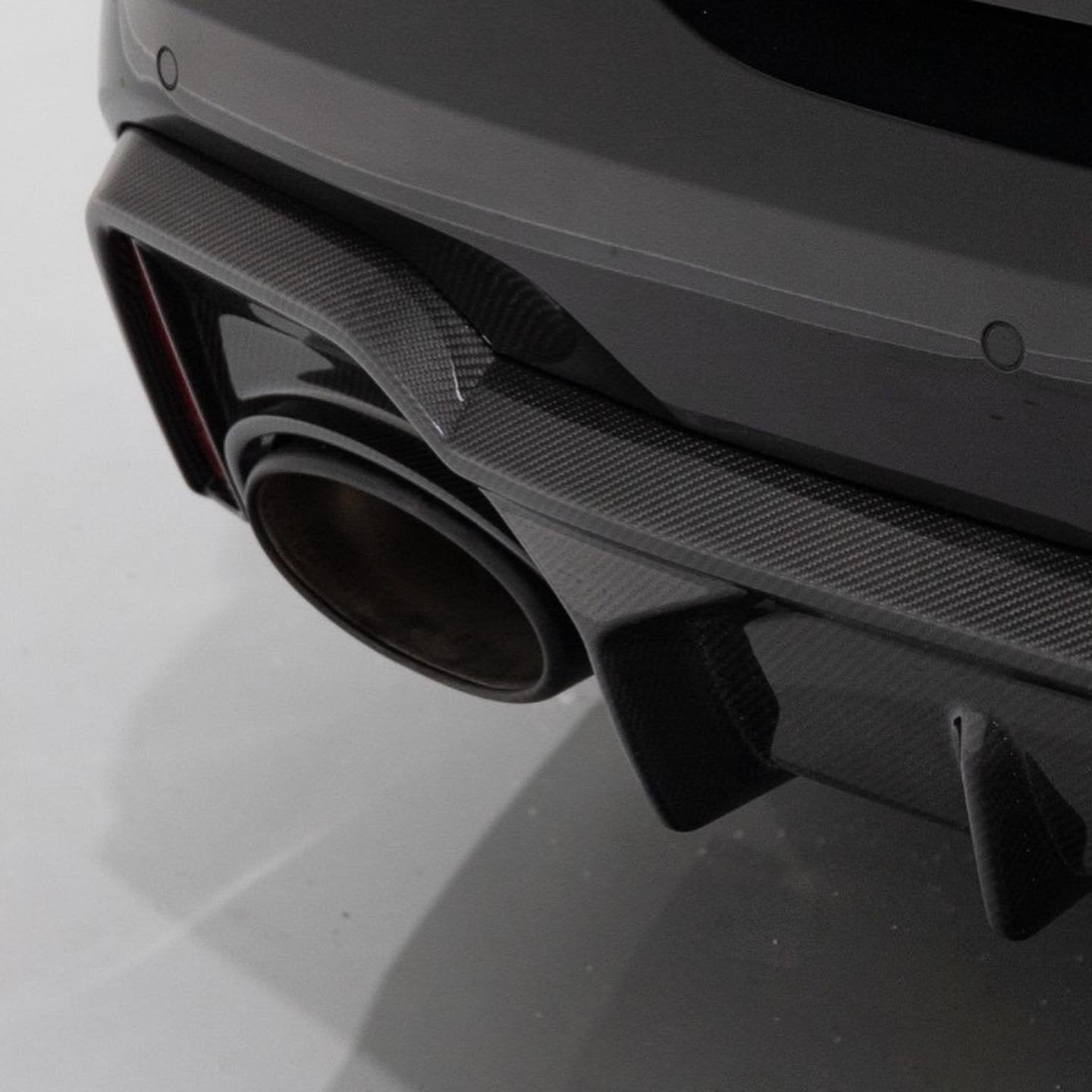 A back close up view of Urban Automotive Carbon Fiber Rear Diffuser Audi C8 RS7 2020+ fitted on a black car