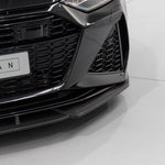 A close up view of a black car fitted with Urban Automotive Carbon Fiber Front Splitter for Audi C8 RS7 2020+