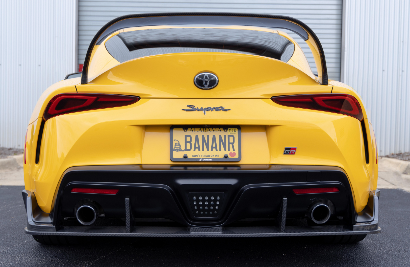 A back view of a yellow car fitted with Dinan Rear Diffuser for Toyota GR Supra 2020-2025 on the road