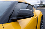 A close up view of a yellow car fitted with one of the mirror cover of the Dinan Mirror Cover Set for Toyota GR Supra 2020-2025 on the road