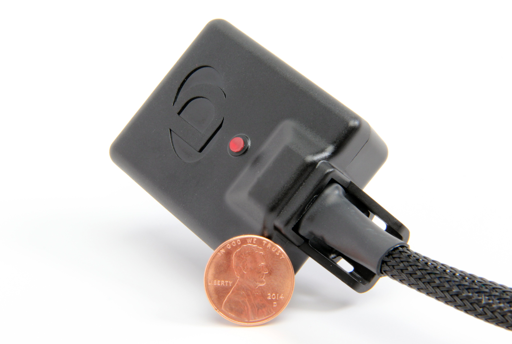 A front view of DINANTRONICS Sport Performance Tuner for BMW / Toyota (B46/B48/B58 Engines) 2016-2025 with white background with a coin as size reference in front of it.