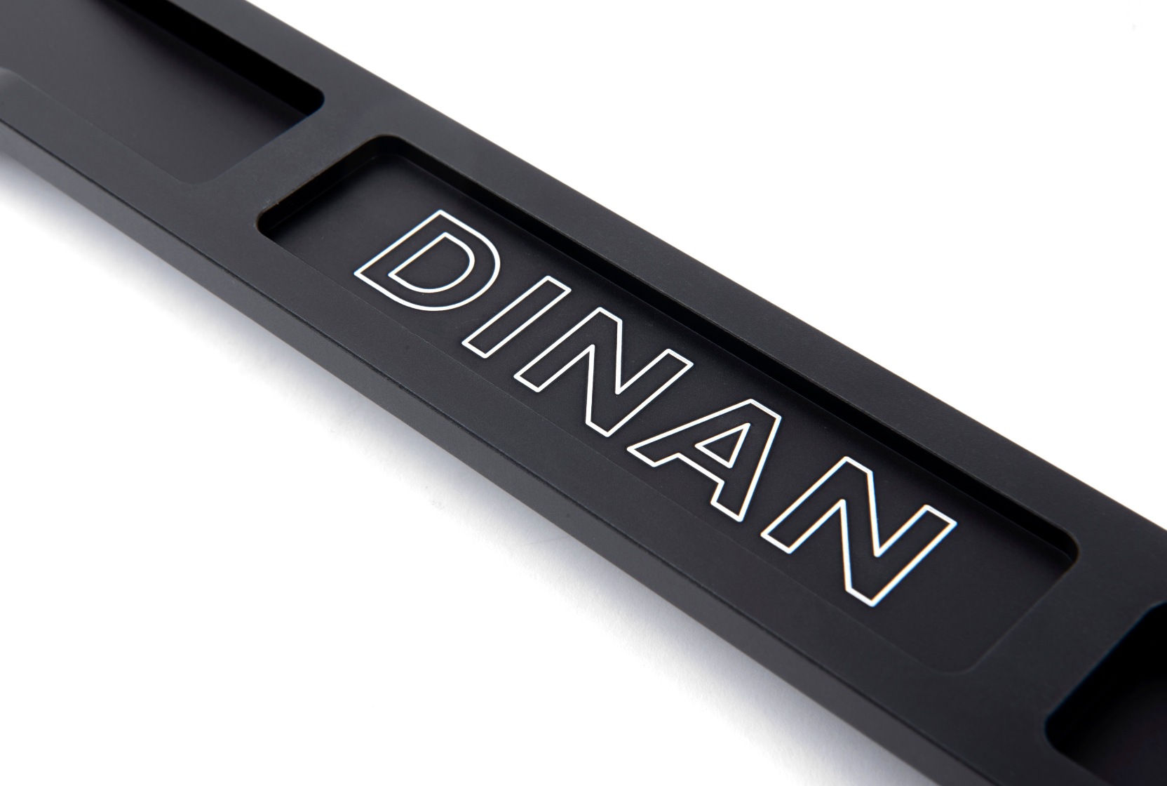 A top close up view of A top view of Dinan Strut Tower Braces for BMW with white background with the dinan logo on the brace
