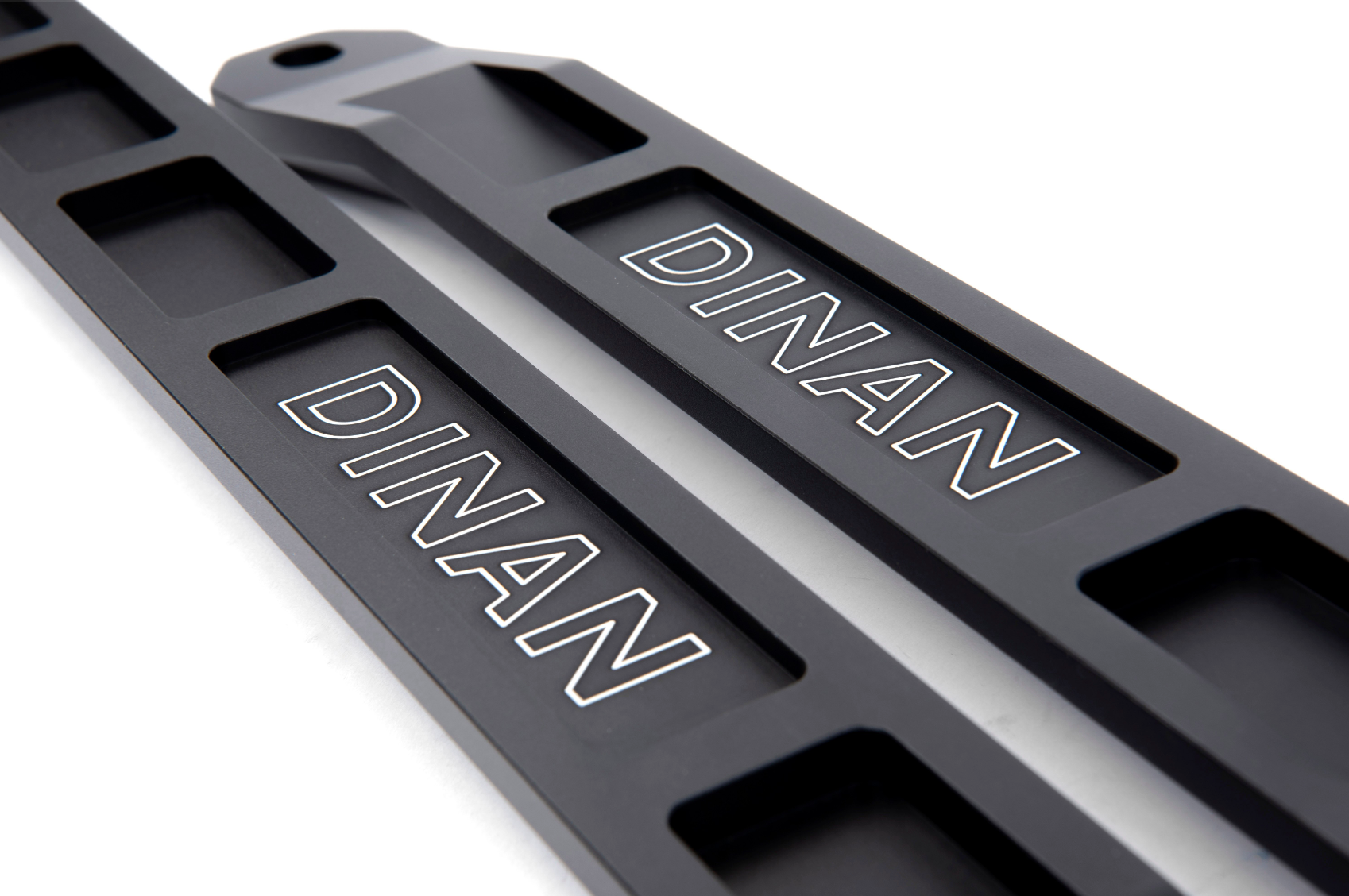A top view of A top view of Dinan Strut Tower Braces for BMW with white background with dinan logo on both braces
