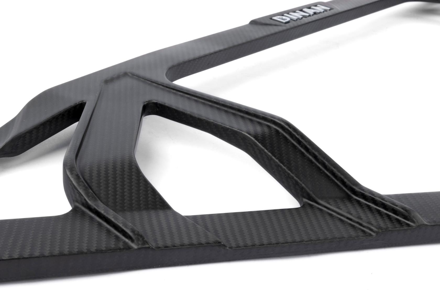A close up view of Dinan Carbon Fiber Strut Tower Brace for BMW M2 / M3 / M4 2021-2025 in matte material with white background