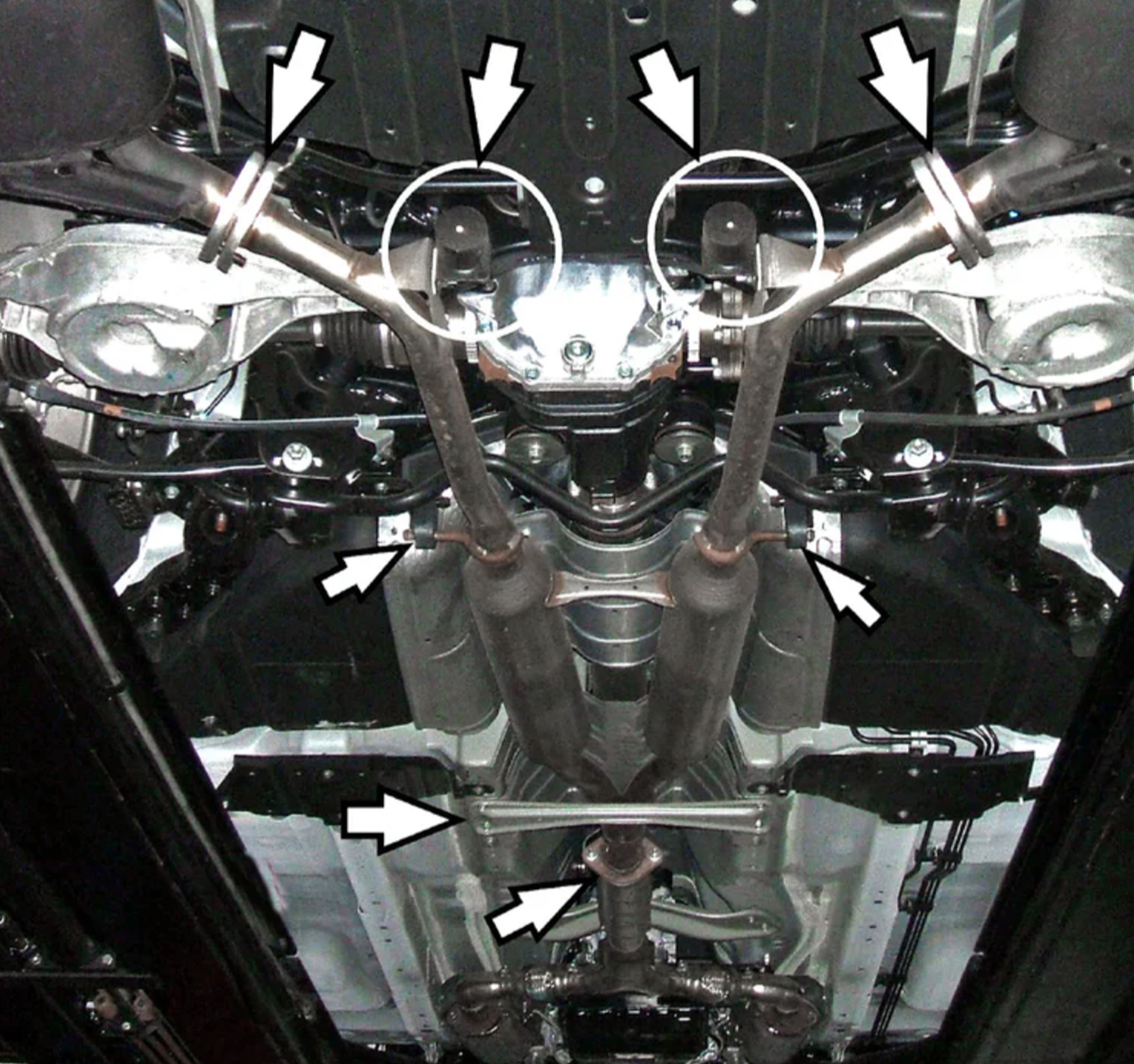 A back view of a lifted car fitted with Stillen Stainless Steel Near Cat-Back Exhaust System for Infiniti M35 2006-2010 with arrows showing the different parts of the exhaust