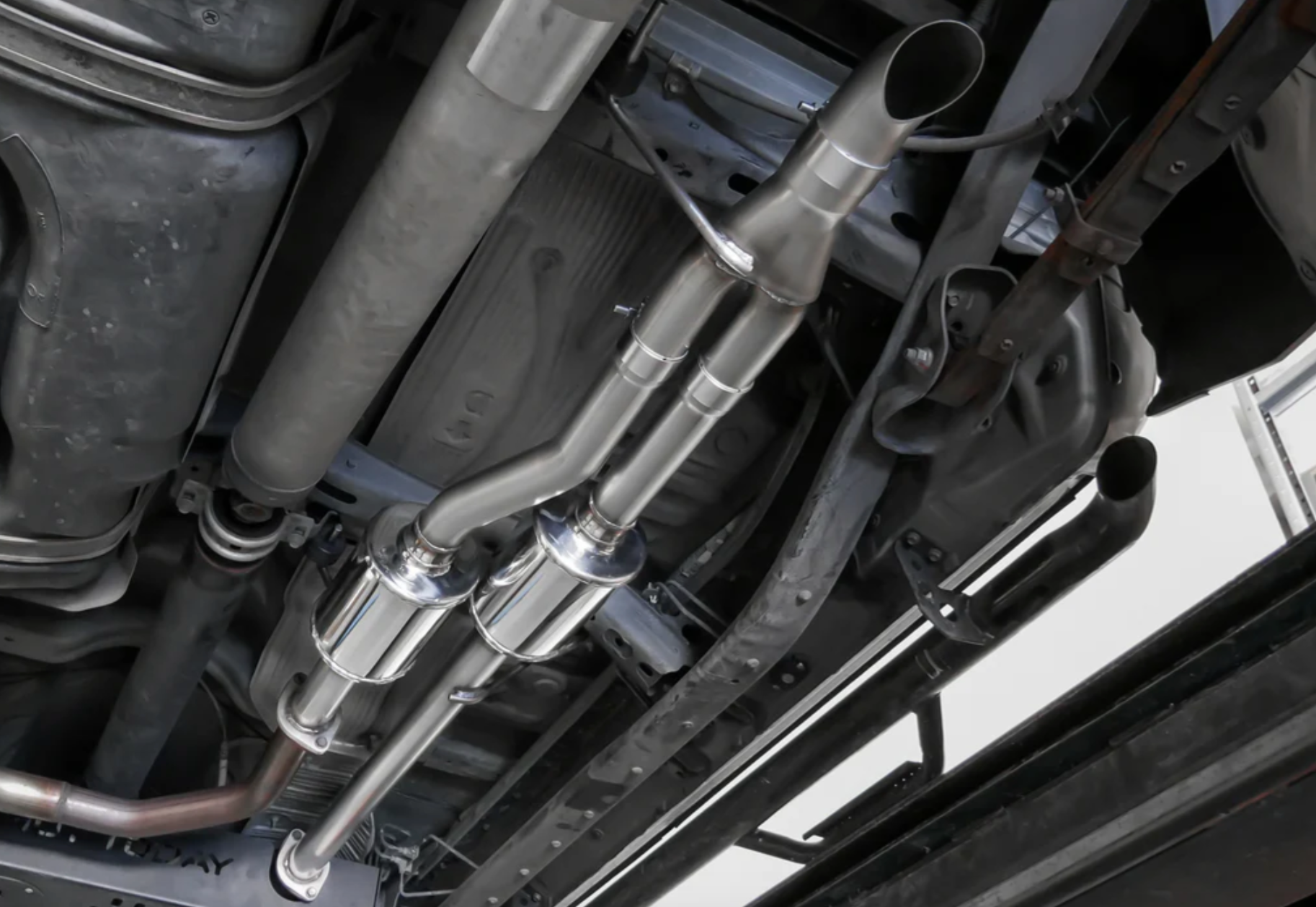 A view of a lifted car from underneath fitted with Stillen Off-Road Series Exhaust for Toyota Tundra 2007-2013