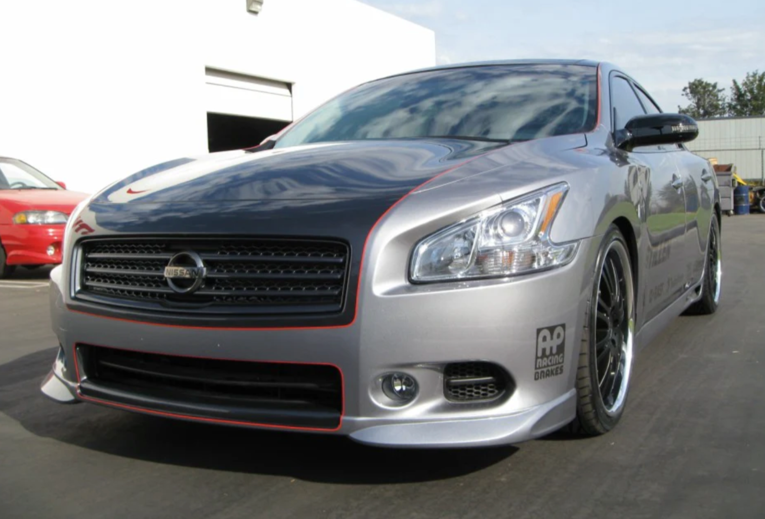 A front wide view of Stillen 7-Piece Body Kit for Nissan Maxima 2009-2015 fitted on a grey car