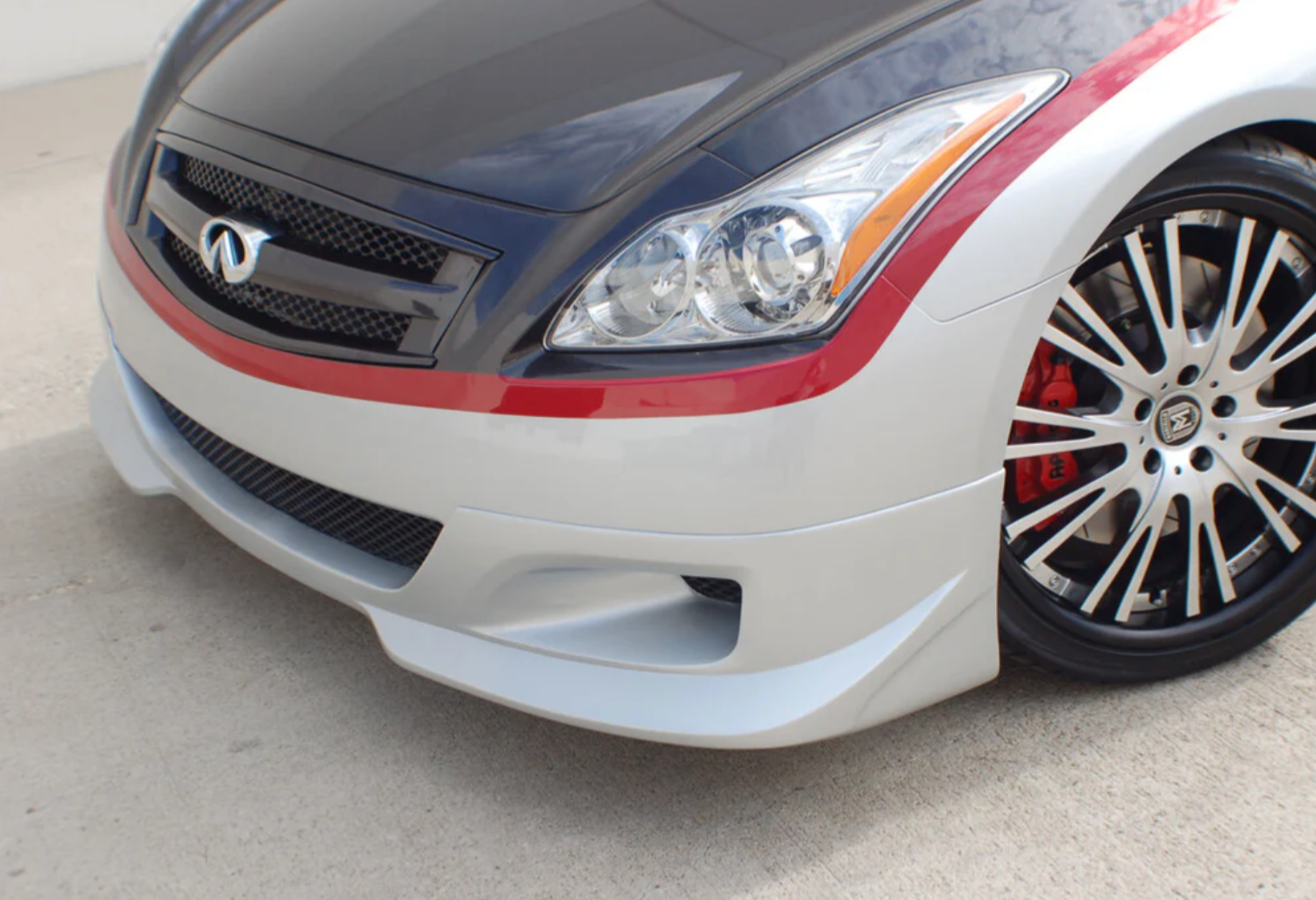 A front side view of a car fitted with Stillen 4-Piece Body Kit for Infiniti G37 Coupe 2008-2013 on the ground