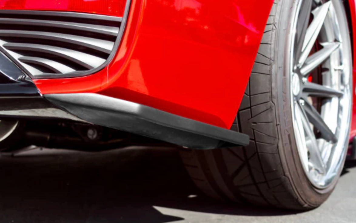 A close up view of the rear corners of the Stillen Side Skirts & Rear Corners [Matte Black] for Infiniti Q60 2017-2022 fitted on a red car