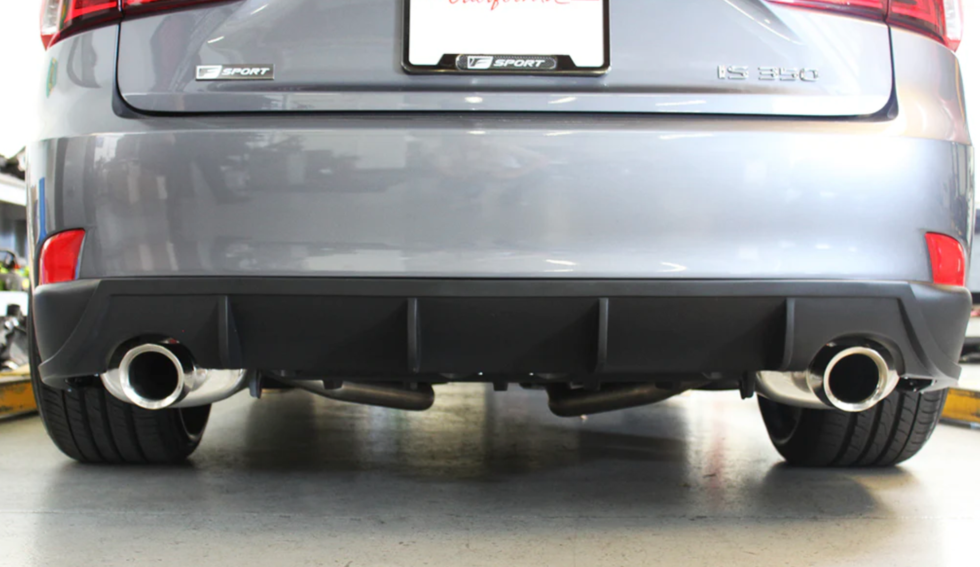 A back close up view of a car fitted with Stillen Rear Diffuser [Matte Black] for Lexus IS250 / IS350 2014-2015 n the ground