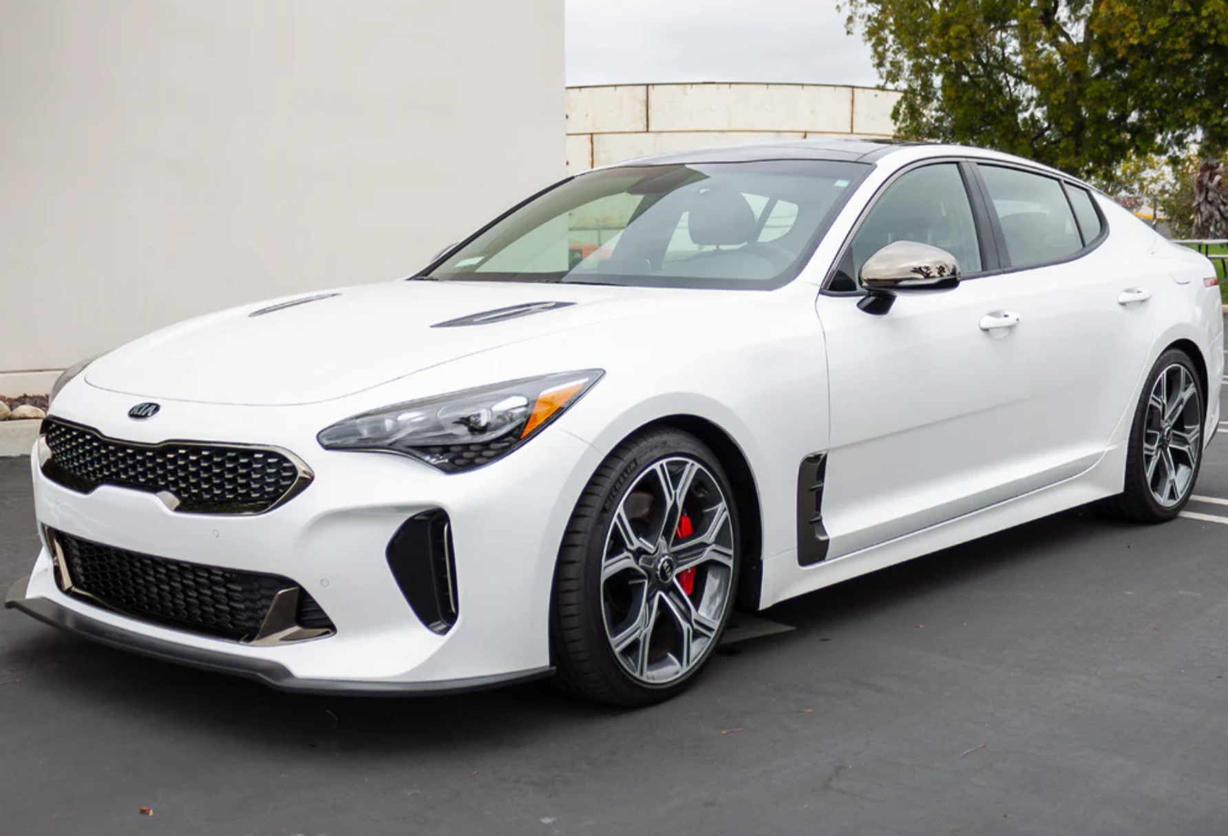 A side wide view of a white car on the ground fitted with Stillen Front Splitter [Matte Black] for Kia Stinger GT (AWD/RWD 3.3TT) 2018-2023