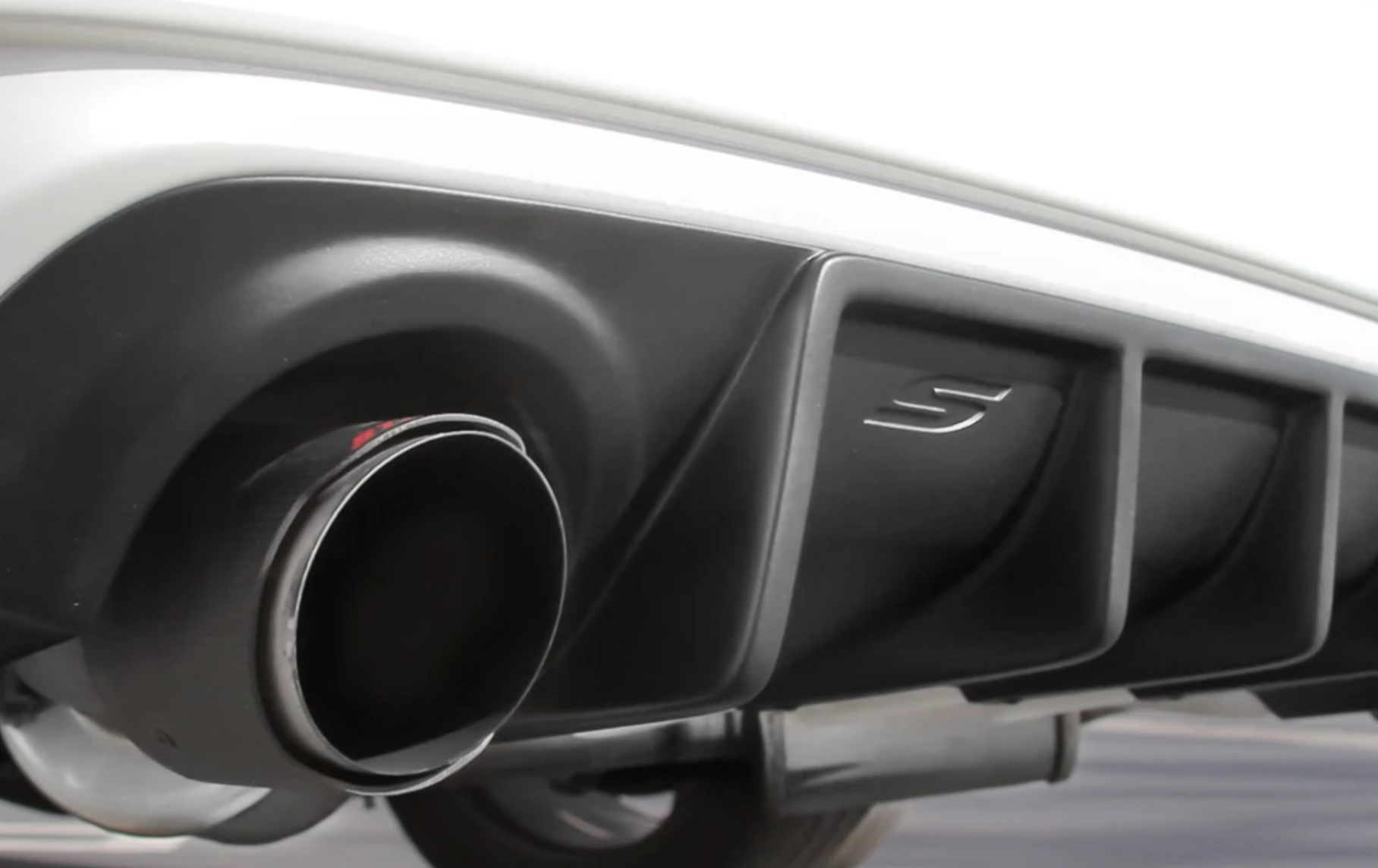 A back close up view of a white car fitted with Stillen Rear Diffuser [UNPAINTED] for Infiniti Q50 2018-2024 on the ground