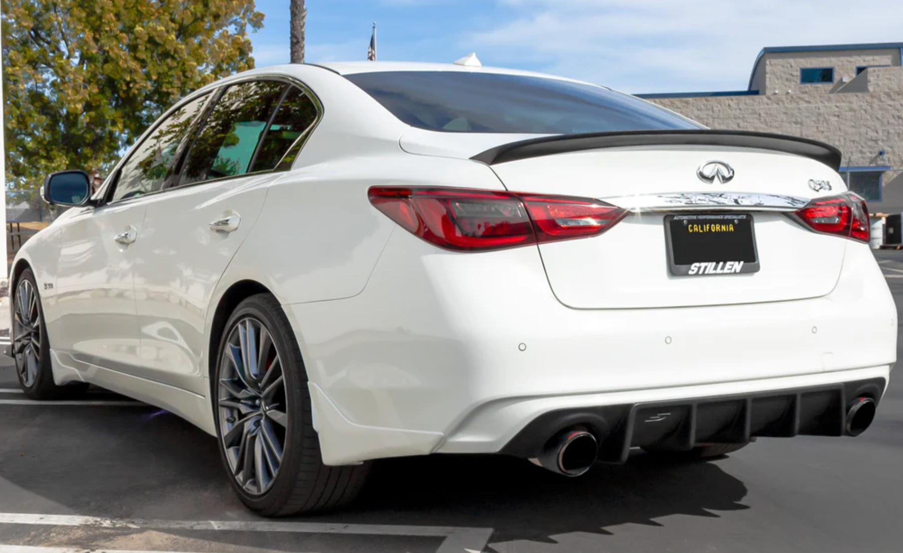 A back wide view of a white car fitted with Stillen Rear Diffuser [UNPAINTED] for Infiniti Q50 2018-2024 on the ground