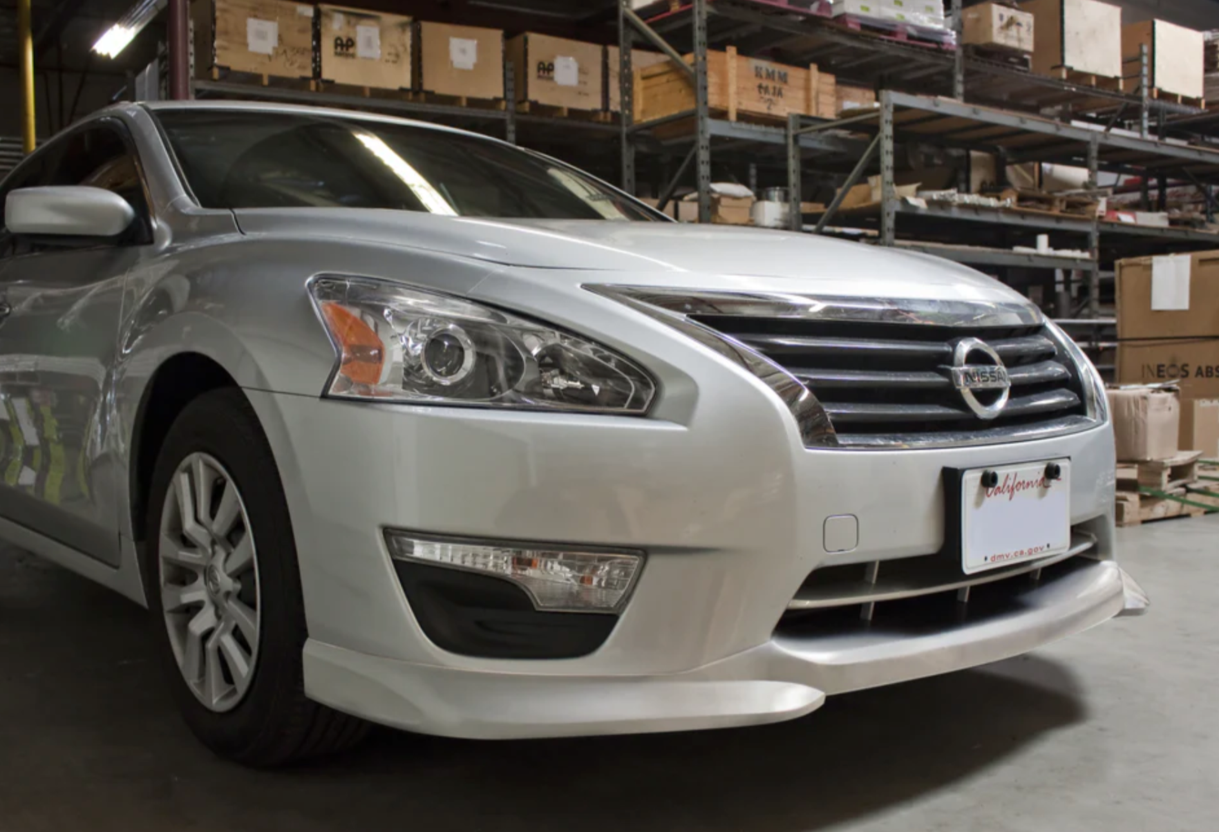 A side close up view of a car in the garage of a warehouse fitted with Stillen Front Lip Spoiler for Nissan Altima 2013-2015