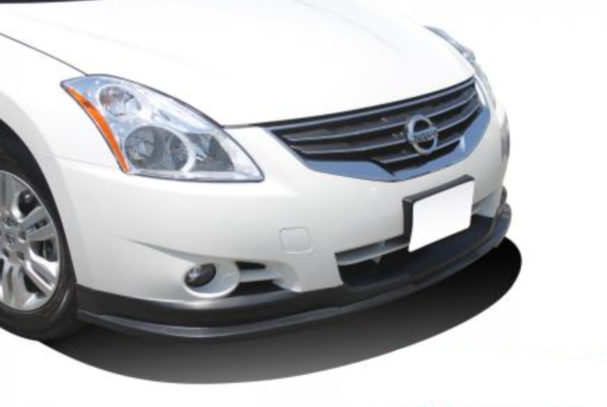A front close up view of a white car fitted with Stillen Front Lip Spoiler for Nissan Altima Sedan 2010-2012 on a white background.
