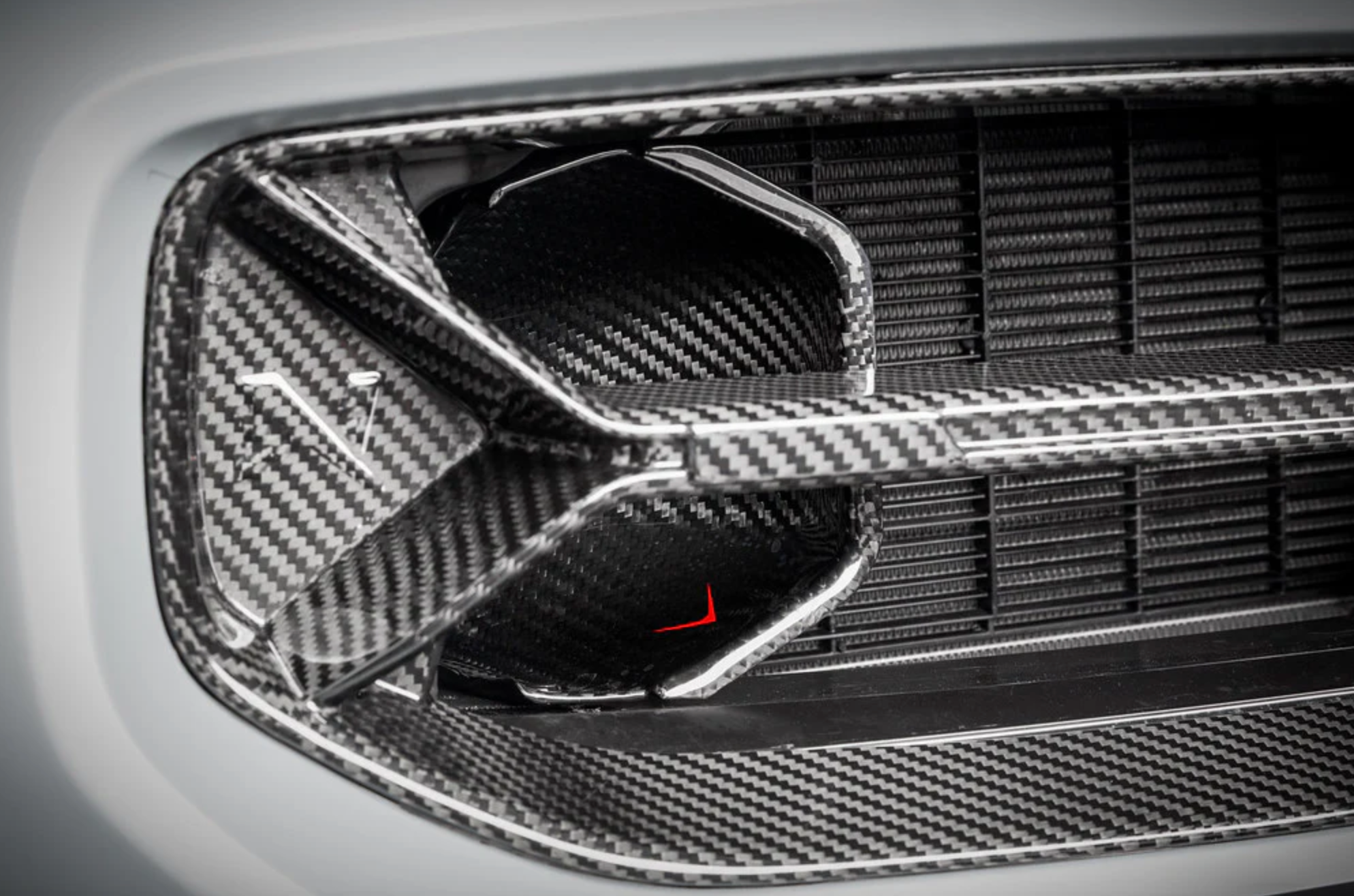 A close up view of one side of the car fitted with Eventuri Black Carbon Intake Scoop Set for BMW G87 M2 2023-2025
