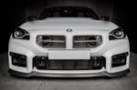 A front wide view of a white car fitted with Eventuri Black Carbon Intake Scoop Set for BMW G87 M2 2023-2025