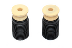 A close-up view of two assembled suspension components from the Dinan kit. Each unit features a cylindrical black accordion-style rubber boot topped with a dense, cream-colored foam progressive bump stop, designed to improve handling and ride quality for the BMW 550i.