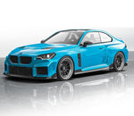A side wide view of Vorsteiner VRS BMW G87 M2 Aero Vented Fenders with Side Skirts Carbon Fiber PP 2x2 Glossy with white background fitted on a blue car