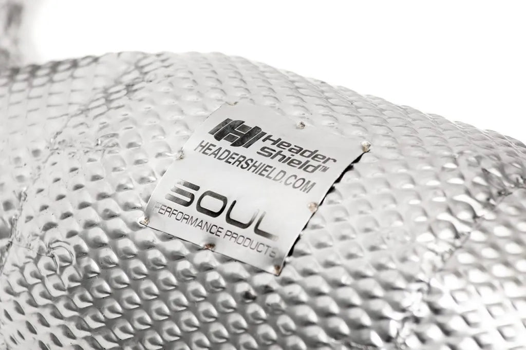 A close up view of Soul Performance Sport Downpipes for McLaren 720S 2019-2025 with white background with the soul performance logo in a steel plate on the downpipe as well