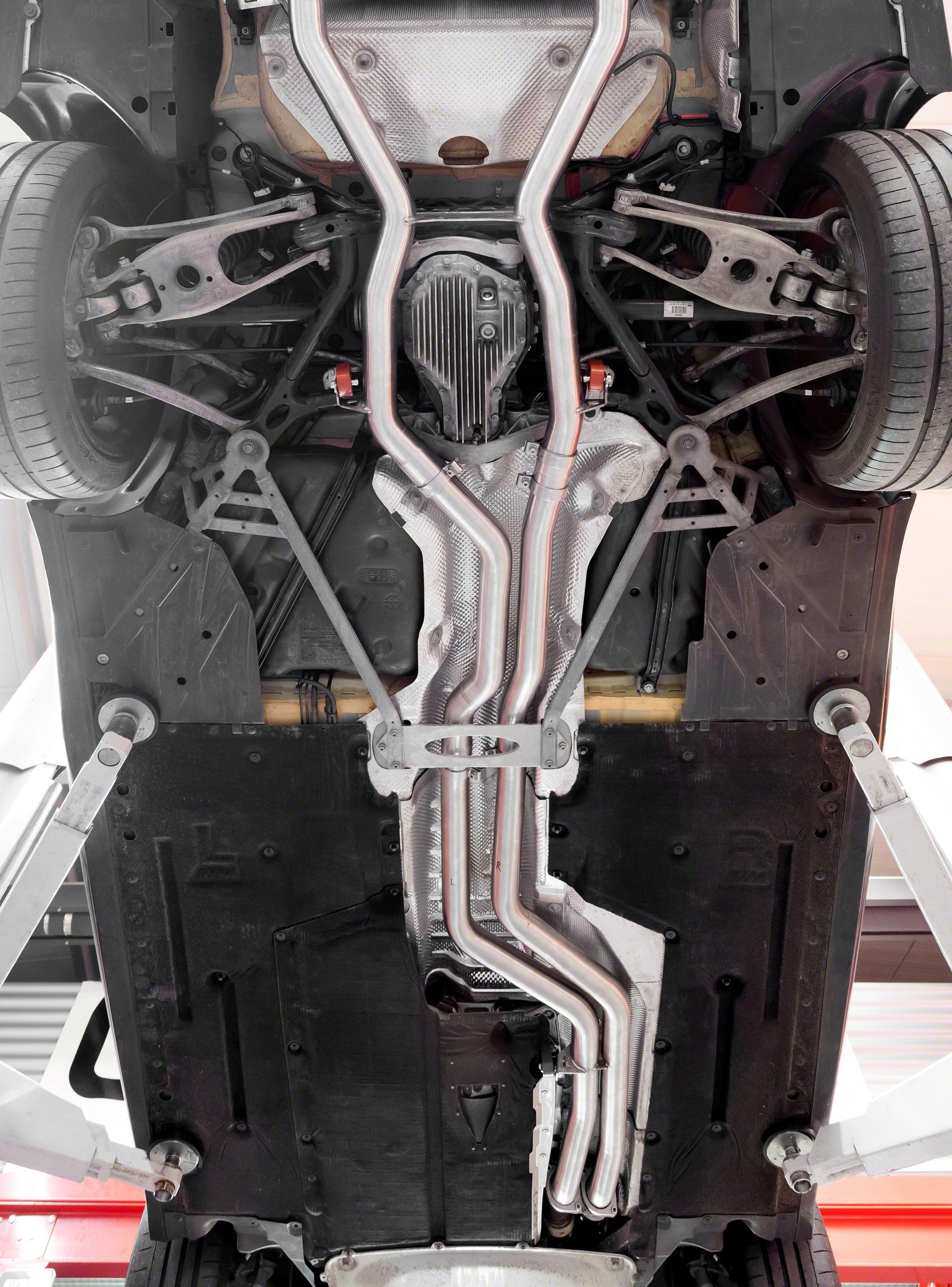 Capristo post cat spare pipes installed under a BMW M3/M4, underbody view
