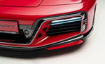 A close up view of TECHART Front Bumper Porsche 992 Turbo /S fitted on a red Porsche with a white background