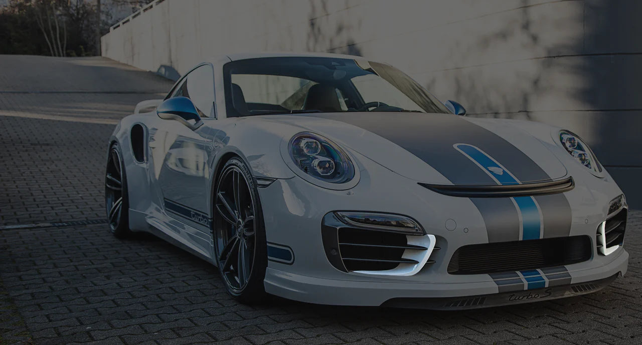 A wide view of TECHART Aero Wings for Porsche 991.1 Turbo until MY16 fitted on a Porsche on the road with the wings highlighted