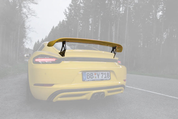 A close up view of TECHART Rear Spoiler II for Porsche 718 Cayman fitted on a yellow car with the spoiler highlighted