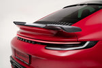 A side close up view of TECHART Rear Spoiler I Carbon "glossy" for 992 Turbo (S) Coupé on a red car