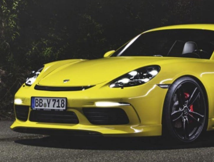 A close up view of TECHART Front Spoiler I Porsche 718 Cayman / Boxster fitted on a yellow Porsche