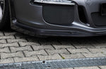 A close up view of TECHART Front Spoiler I Matt Carbon Fiber Porsche 991.1 GT3 / RS fitted on a car on the ground