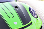 A close up view of TECHART Aero Hood Partially Coated Glossy Carbon Fiber Porsche 991.2 GT3 RS fitted on a green Porsche
