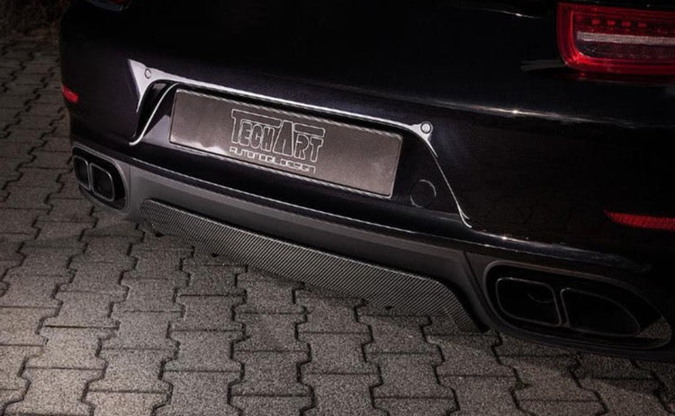 A close up view of TECHART Rear Diffuser Matt Carbon Fiber Porsche 991.2 Carrera / Targa fitted on a black Porsche