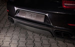 A close up view of TECHART Rear Diffuser Glossy Carbon Fiber Porsche 991.1 Carrera / Targa fitted on a black Porsche