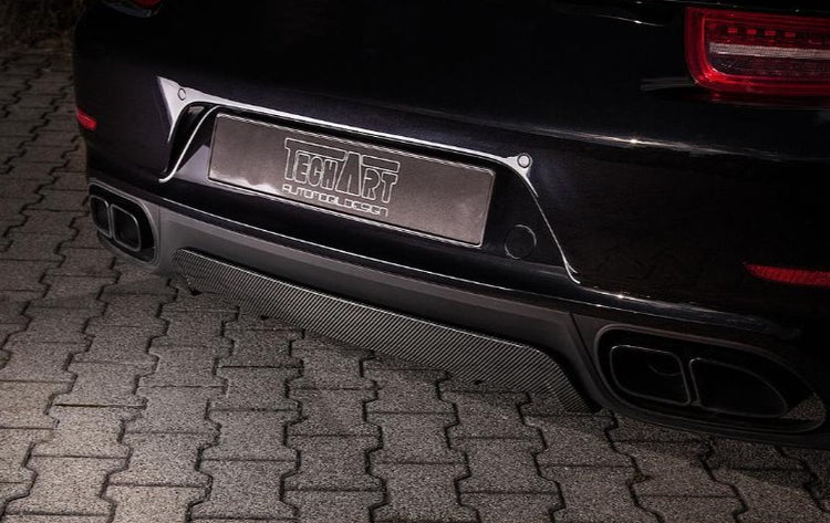 A close up back view of TECHART Rear Diffuser Glossy Carbon Fiber Porsche 991.1 Turbo / S fitted on a black Porsche